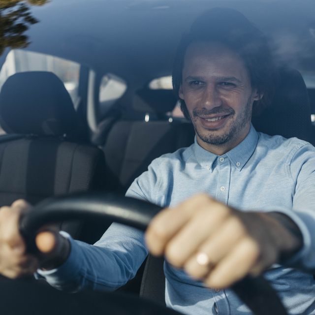 smiling businessman driving car