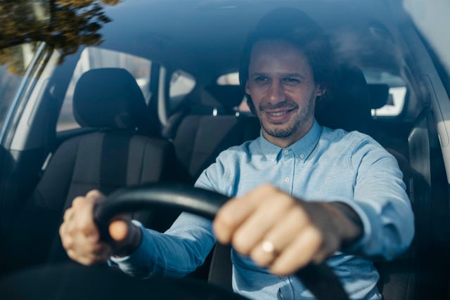 smiling businessman driving car