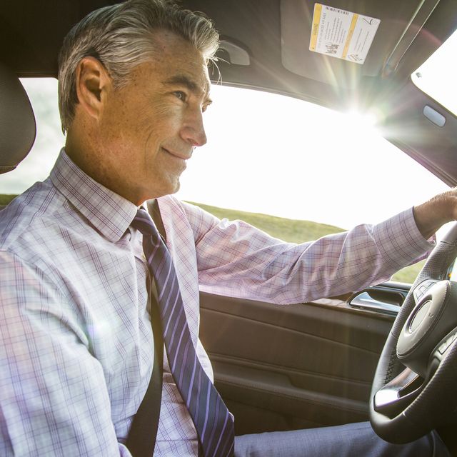 smiling caucasian businessman driving car