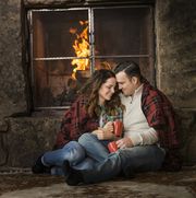 smiling caucasian couple cuddling on floor near fireplace