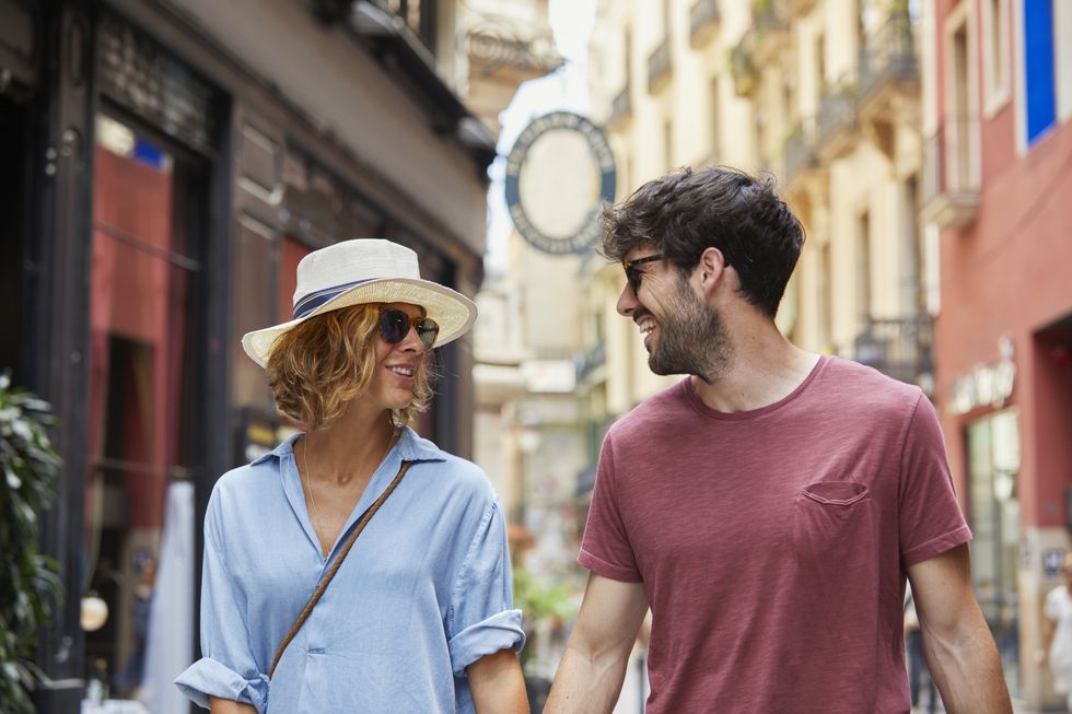 Smiling couple walking on street in Barcelona