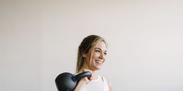 https://hips.hearstapps.com/hmg-prod/images/smiling-female-athlete-carrying-kettlebell-while-royalty-free-image-1740511080.pjpeg?crop=0.756xw:0.566xh;0.0978xw,0.247xh&resize=640:*