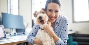 Smiling female entrepreneur sitting with dog