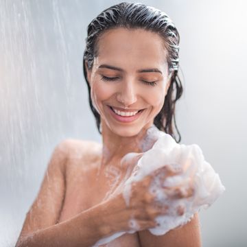 smiling female rubbing body with foam