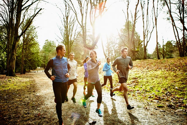 Smiling friends running together in park