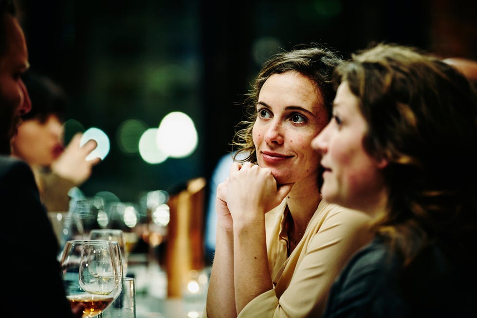 smiling friends talking at dinner party