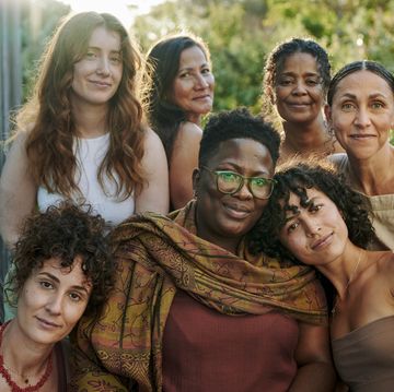 smiling group of diverse women sitting on a patio during a wellness retreat