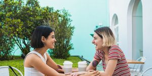 smiling lesbians enjoying coffee on table