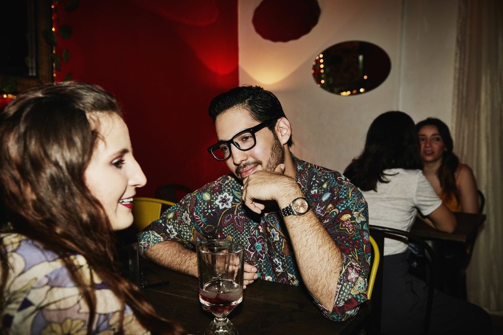 smiling man admiring girlfriend while on date in night club