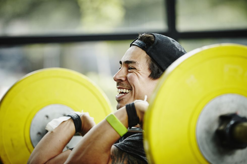 smiling man preparing to press barbell over head
