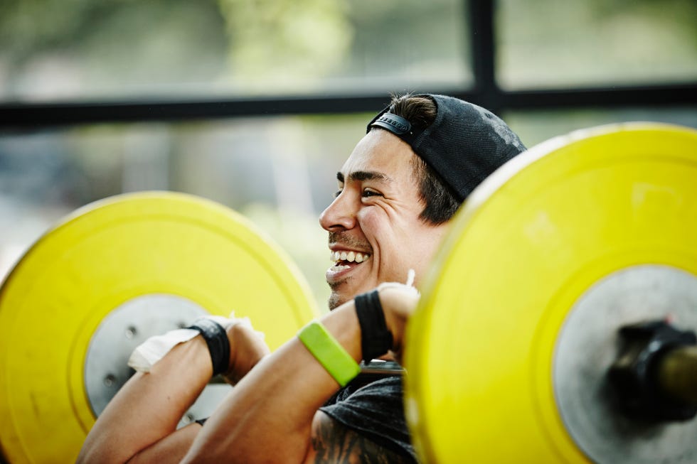 smiling man preparing to press barbell over head