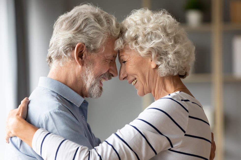 smiling mature husband and wife share romantic moment together