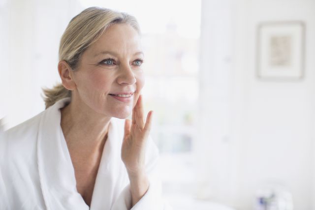 mujer echandose crema feliz y sonriente
