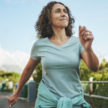 smiling mature woman out for a power walk in summer