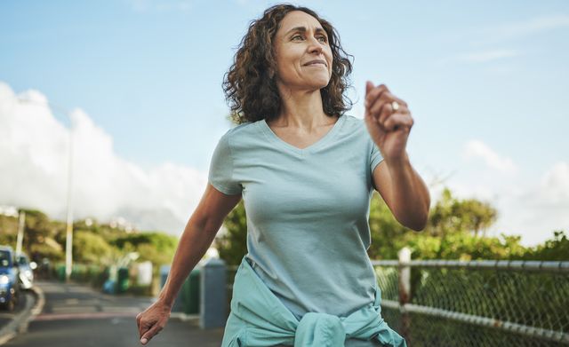 smiling mature woman out for a power walk in summer
