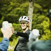 smiling mature woman toasting beers with friends after mountain bike ride