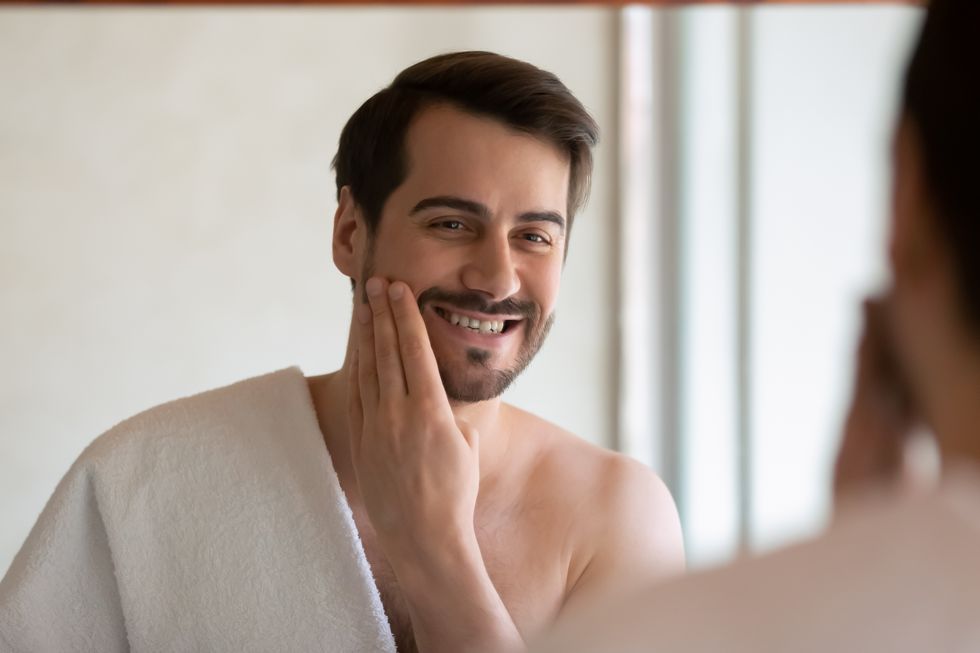 顔に化粧水をつける男性