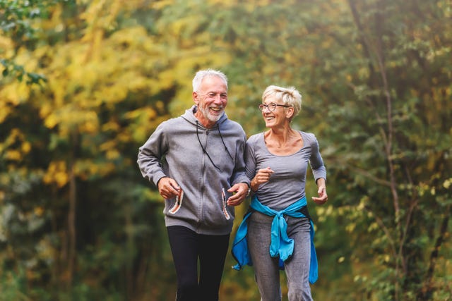 smiling senior couple jogging in the park