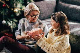 madre con niña sonriendo recibiendo regalo