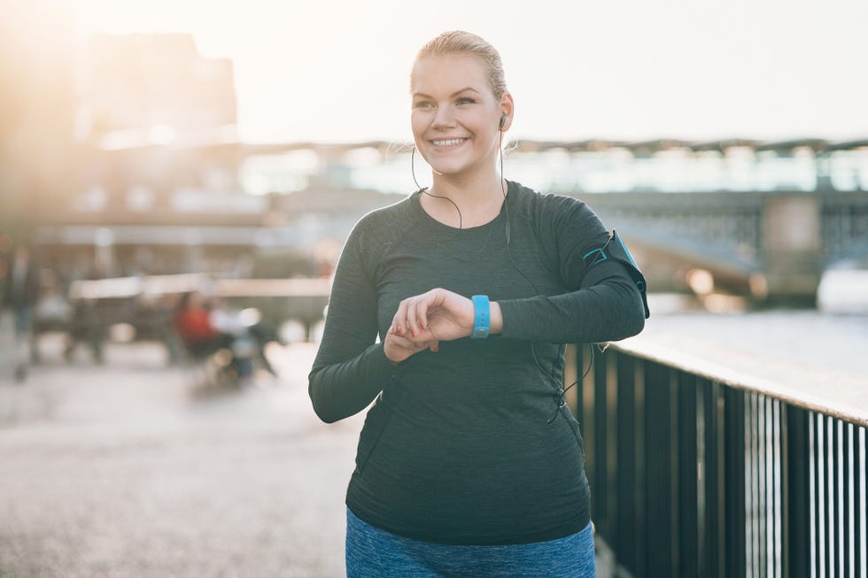 Smiling sportswoman checking her smart watch