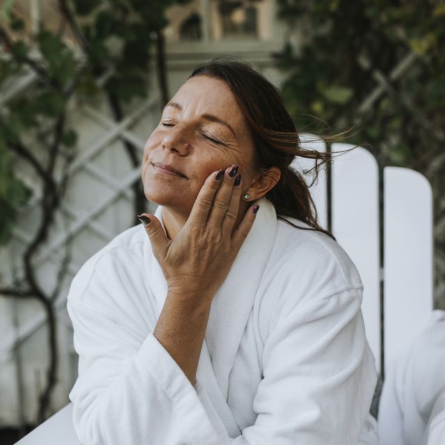smiling woman applying face cream
