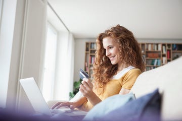 una mujer se dispone a realizar compras online con ordenador y tarjeta de crédito