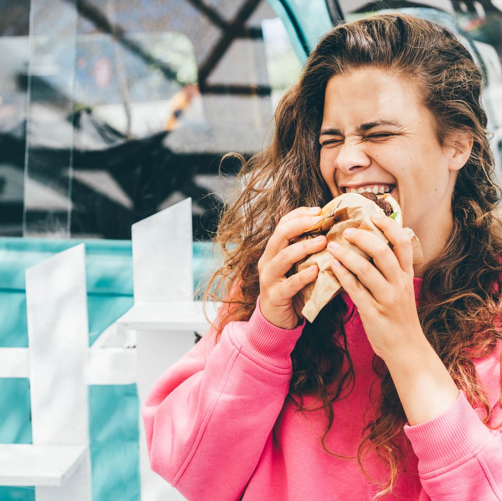 smiling woman eating hamburger