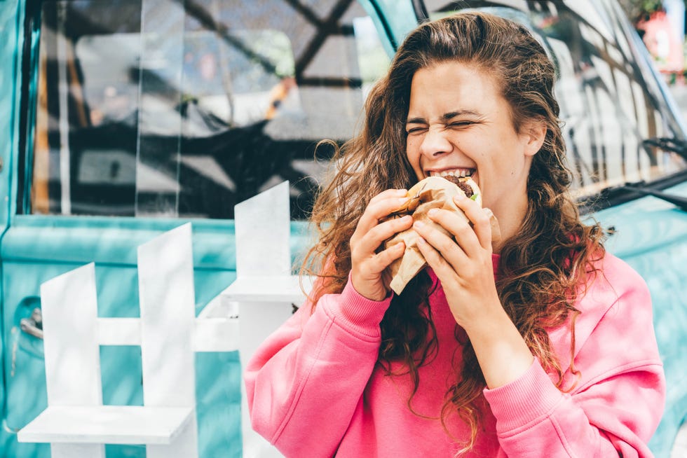 smiling woman eating hamburger