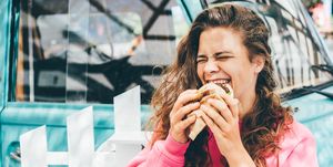 smiling woman eating hamburger