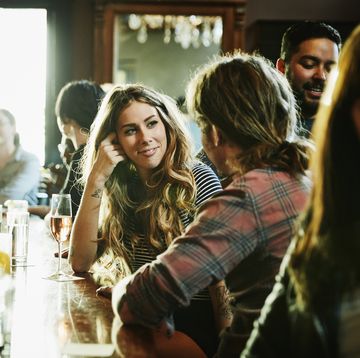 Smiling woman flirting with man while sitting in bar