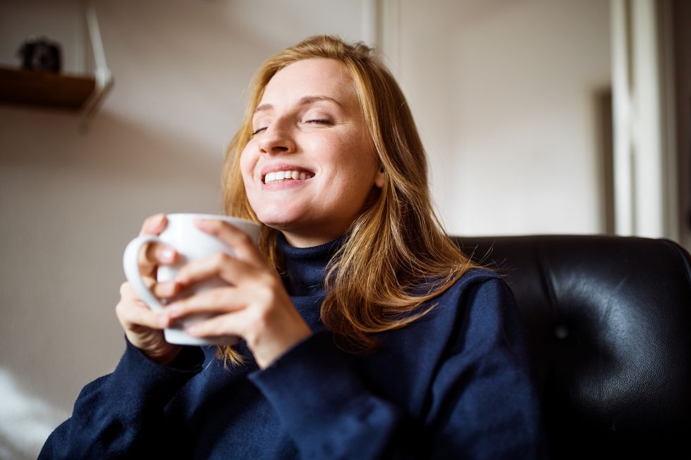 smiling woman having coffee at home
