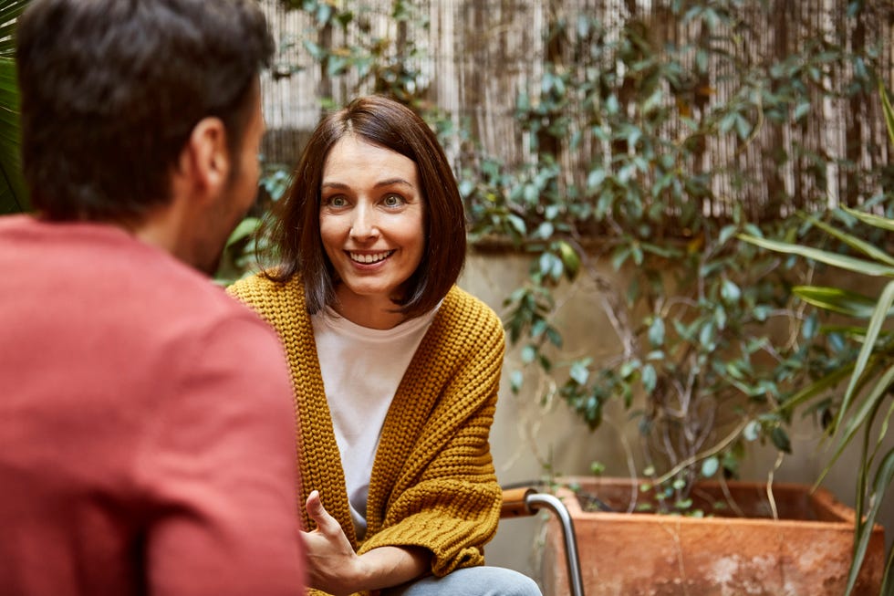 smiling woman looking at man in yard