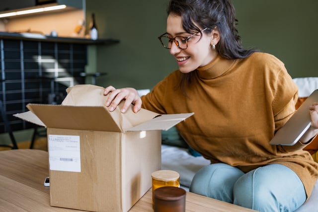 smiling woman opening a delivery box