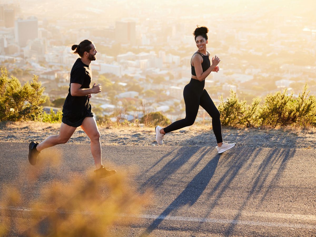 Mujer y hombre sanos con ropa deportiva corriendo entre sí dando un alto  cinco mientras entrenan en el ejercicio en el gimnasio