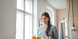 Smiling woman serving healthy breakfast in tray