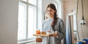 smiling woman serving healthy breakfast in tray