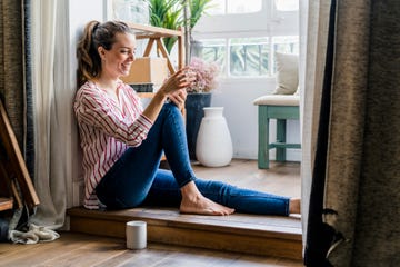 Una mujer se divierte desde casa gracias a la agenda de planes online que proponemos.