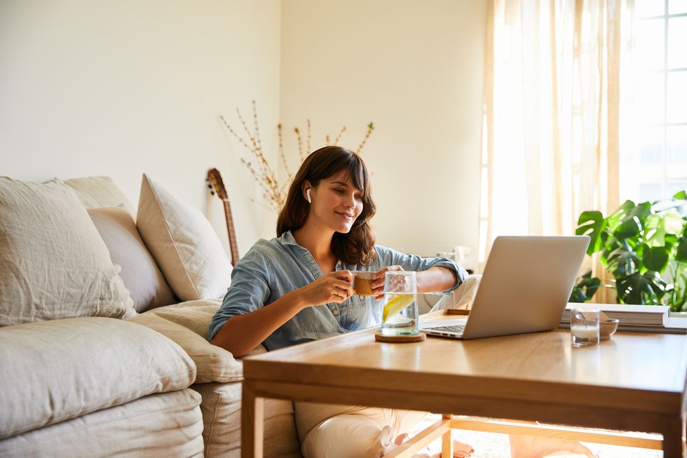 smiling woman watching something on a laptop at home