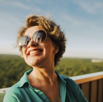 mujer sonriente con gafas de sol