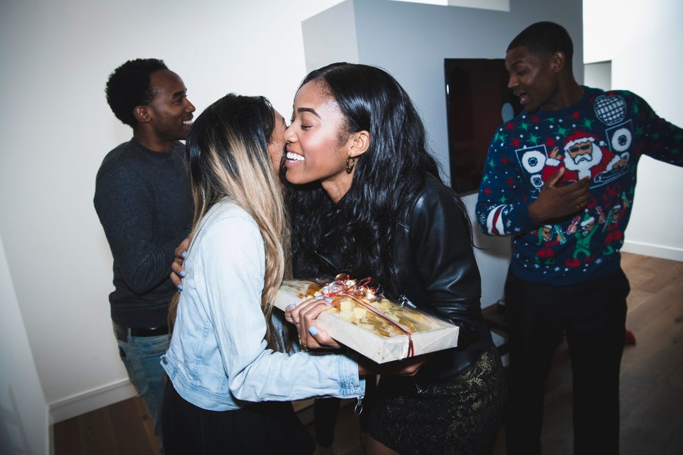 smiling woman welcoming friends at christmas party