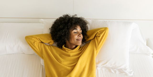 https://hips.hearstapps.com/hmg-prod/images/smiling-woman-with-closed-eyes-lying-on-bed-royalty-free-image-1615928371.?crop=1.00xw:0.752xh;0,0.0577xh&resize=640:*