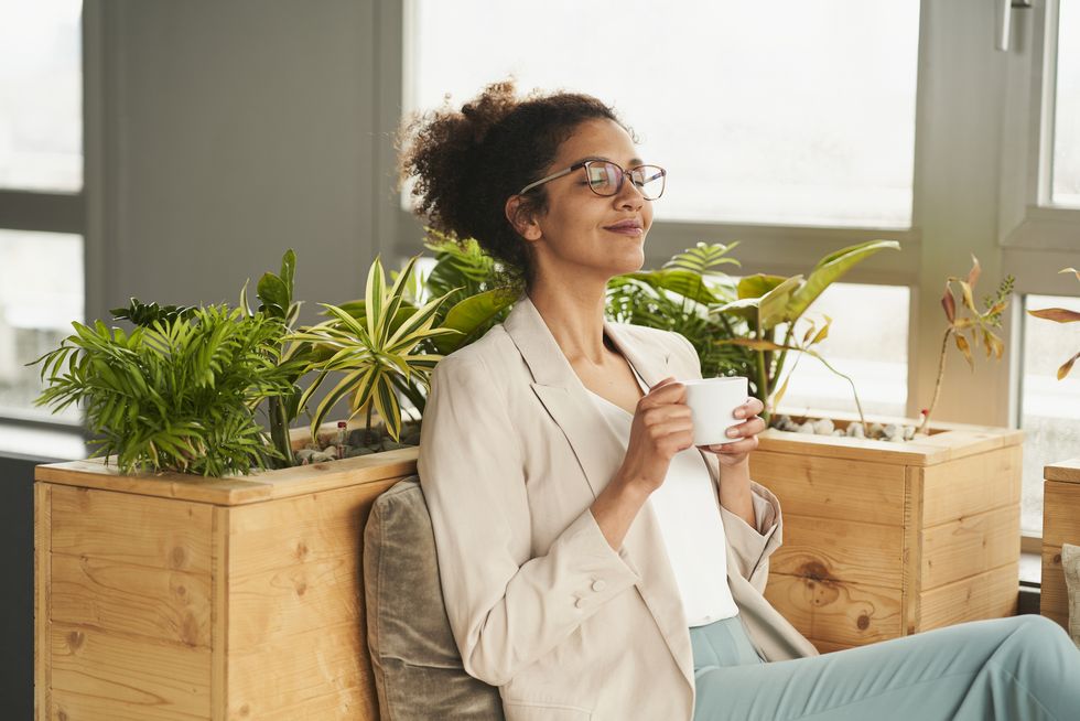 smiling woman with coffee cup sitting in office