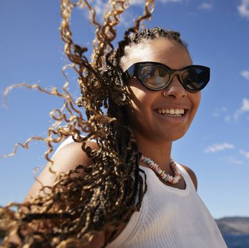 smiling woman with tousled braided hair in wind