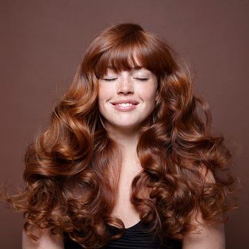 smiling woman with windblown red long hair