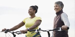 Smiling women with bicycles looking away