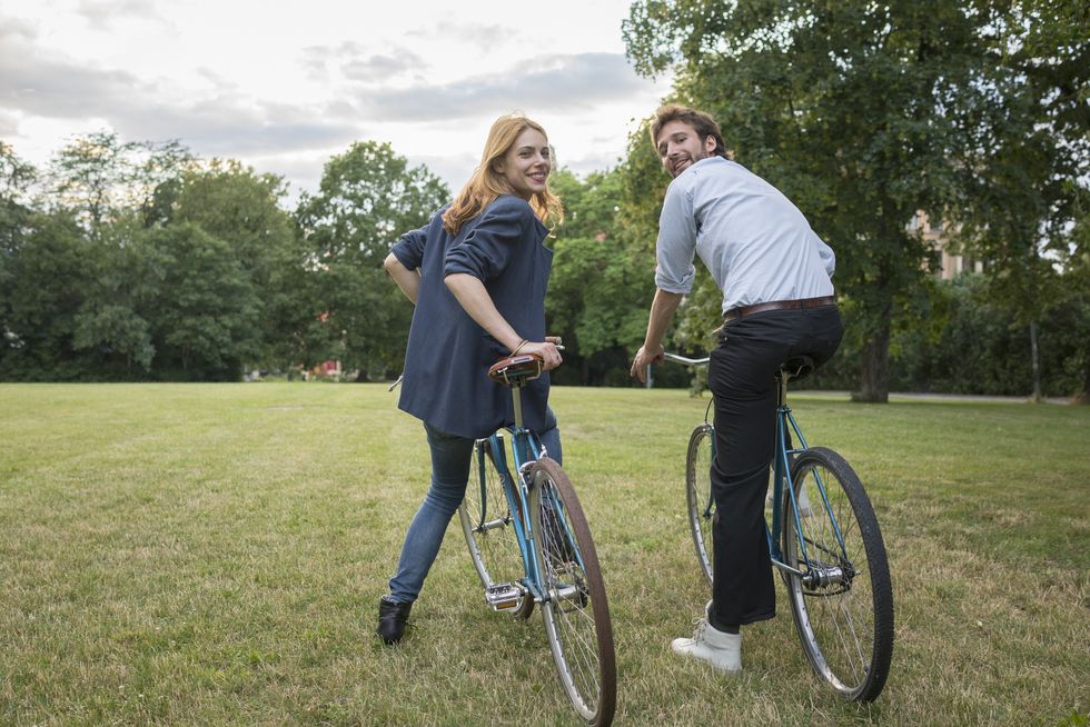 smiling young couple with bicycles in park
