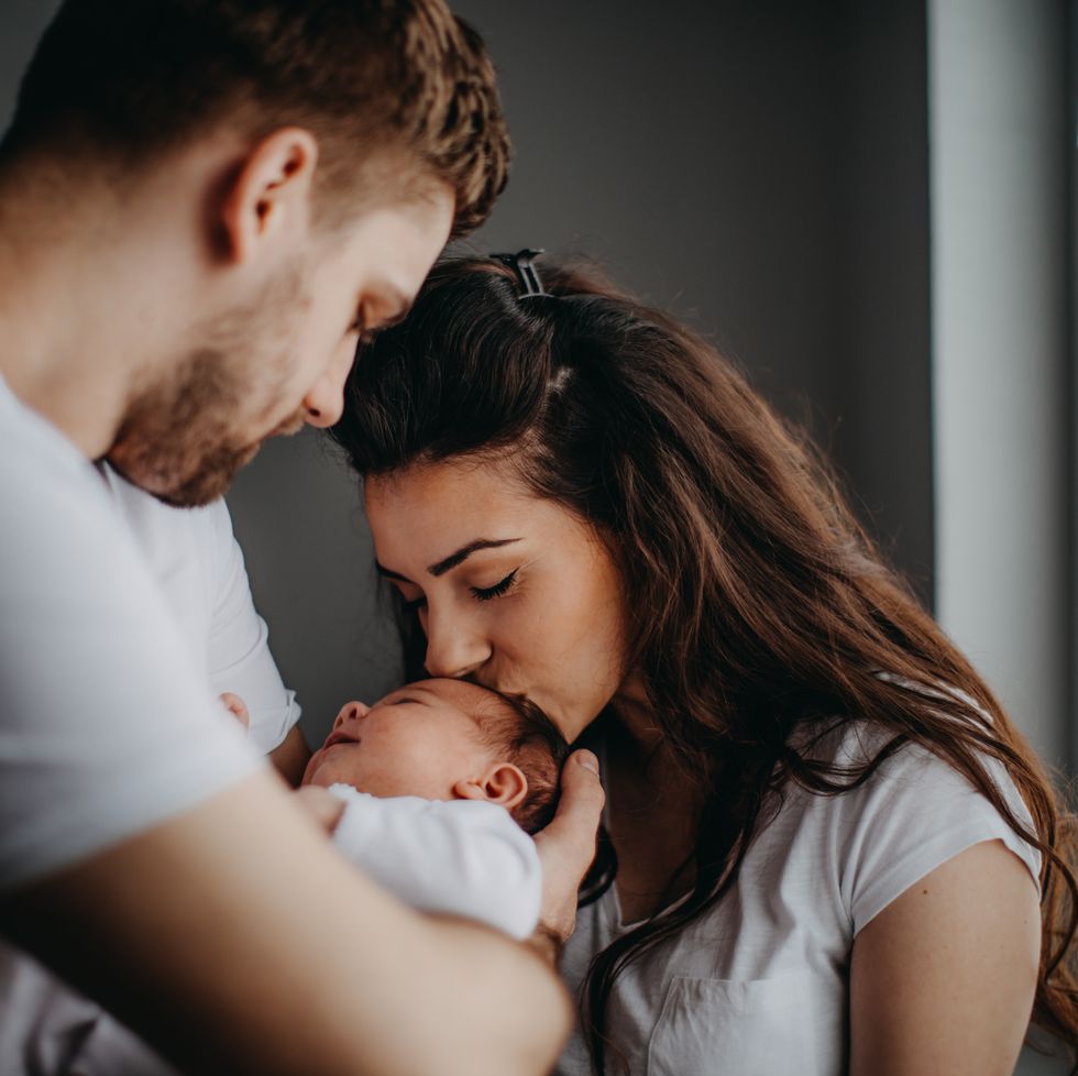smiling young parents with their baby girl at home