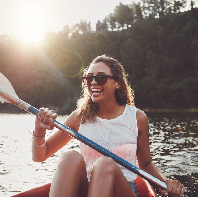 smiling young woman kayaking on a lake