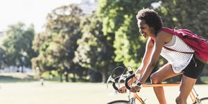 Smiling young woman riding bicycle in park