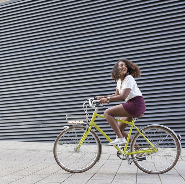 smiling young woman riding bicycle